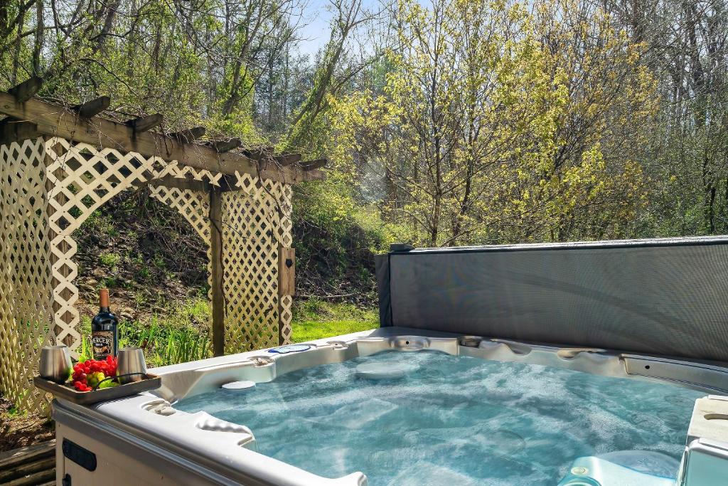 a hot tub in a backyard with a pergola at Fireflies and Moonshine in Gatlinburg