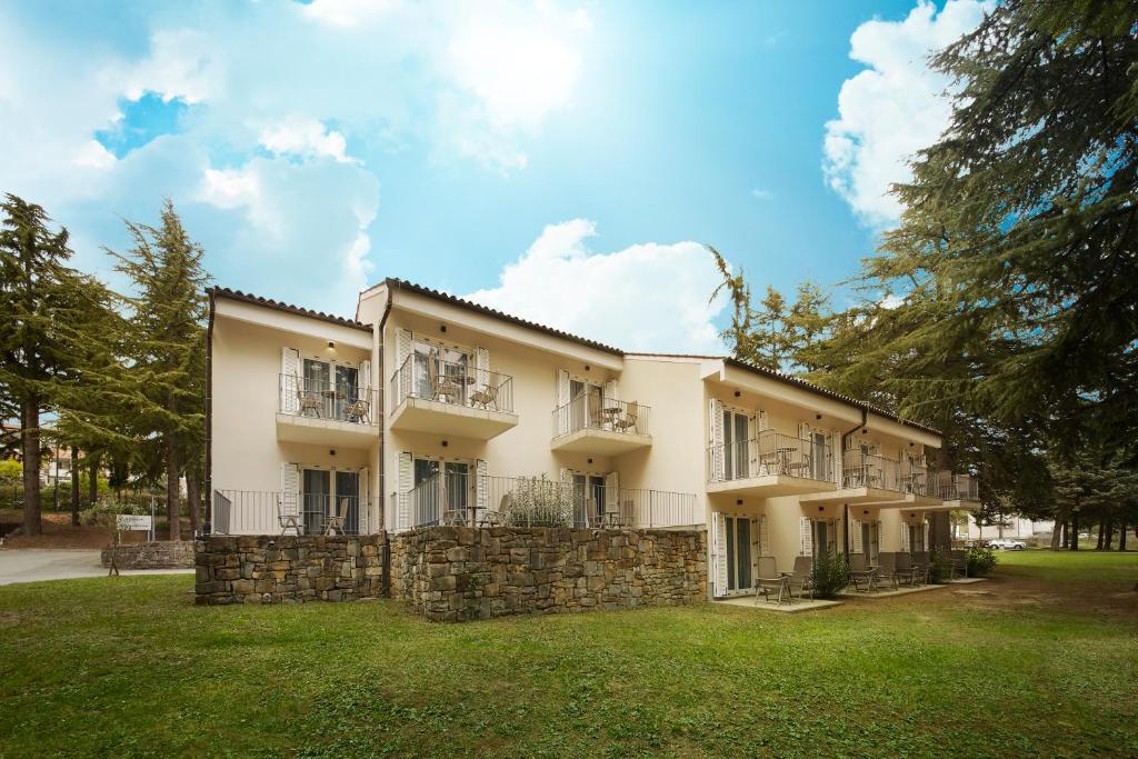 un gran edificio blanco con una pared de piedra en Villa Cedra - Hotel & Resort Adria Ankaran, en Ankaran