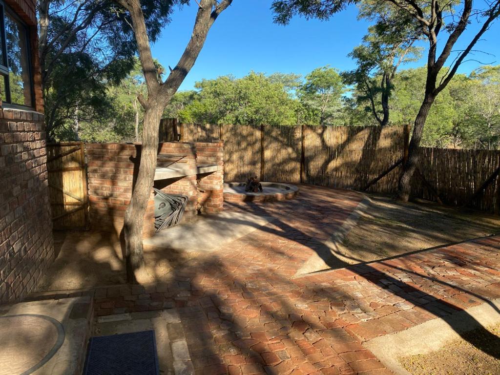 a patio with a tree and a fence at Vlakkieskraal Farmstay - BushBaby House in Bela-Bela