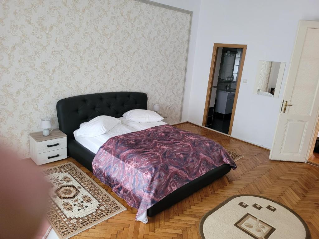 1 dormitorio con 1 cama con cabecero negro y espejo en Casa Anda, en Sibiu