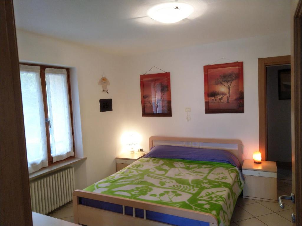 a bedroom with a bed and two windows at Appartamento SUNRELAX in Riva del Garda