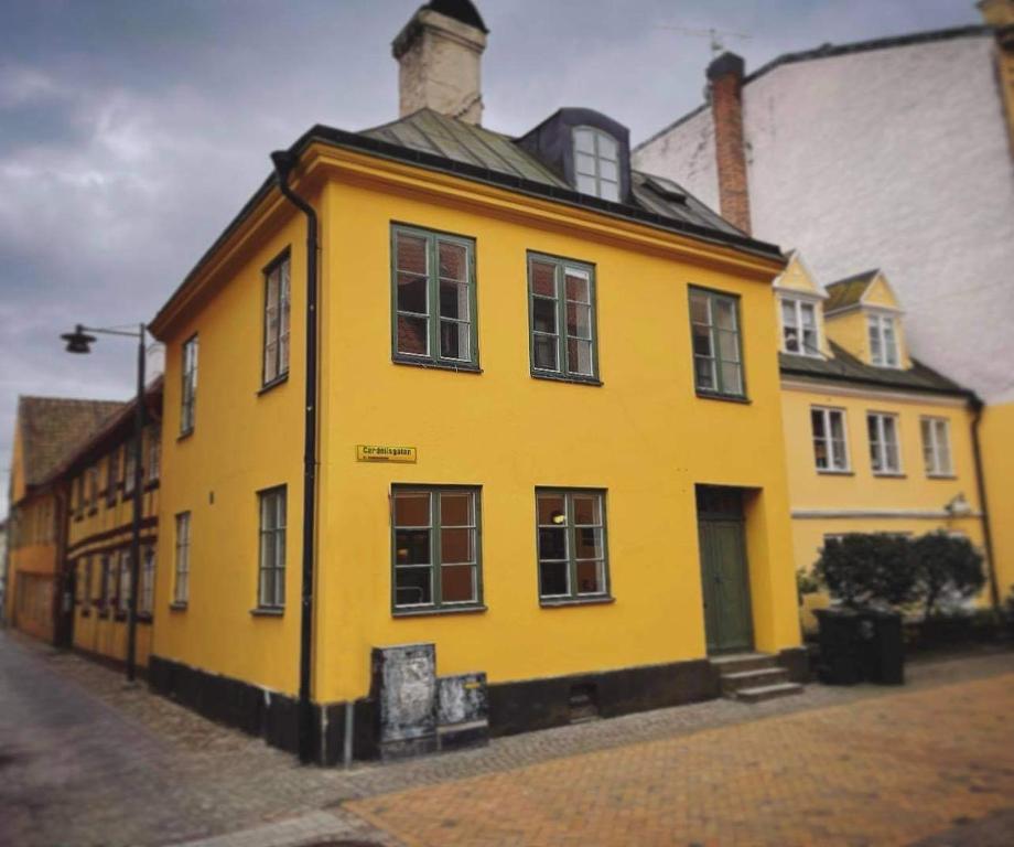 un edificio amarillo con ventanas en una calle en Kristianstad Guest House en Kristianstad