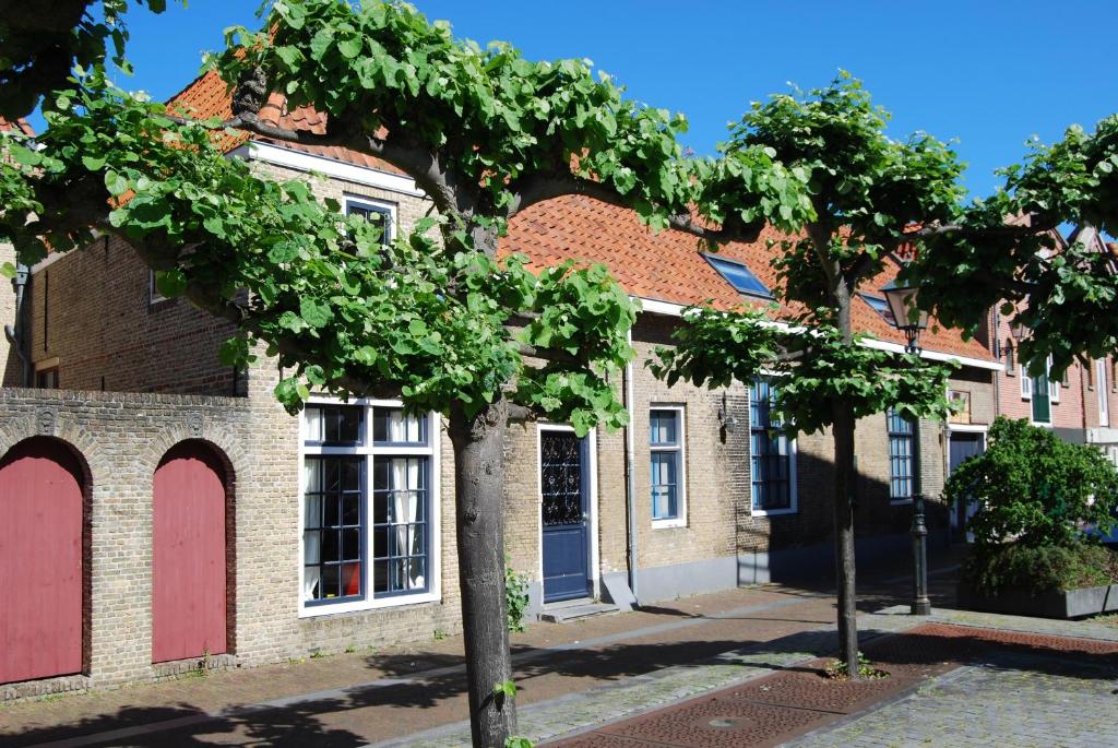 two trees in front of a brick building at Lant van Beloften in Vlissingen