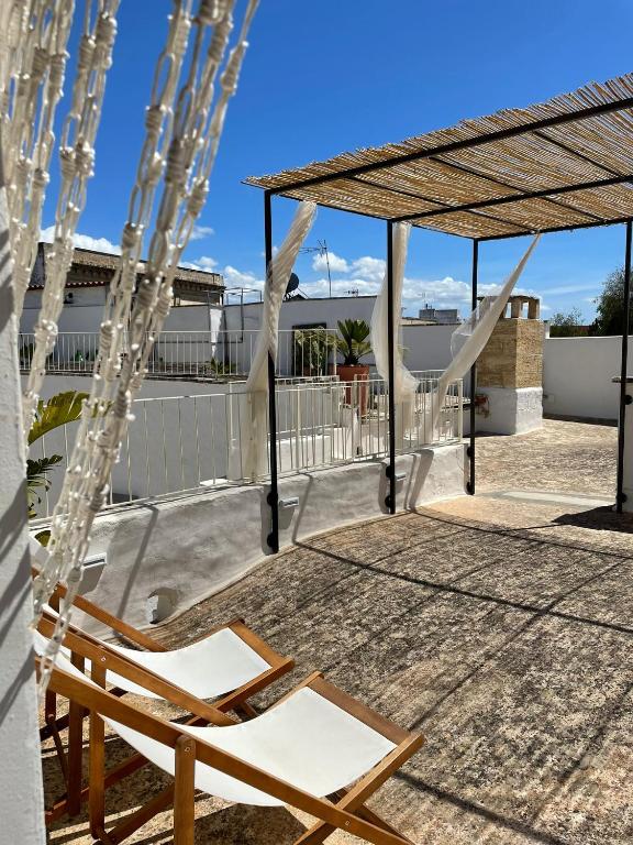 a deck with a chair and a pergola at CORTE LARGO LAURO DIMORE & SPA in Gemini