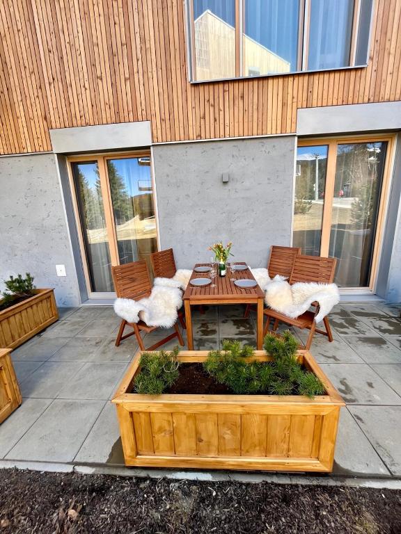 a patio with two chairs and a wooden table and chairs at Ski Apartment Hillside in Dolný Kubín