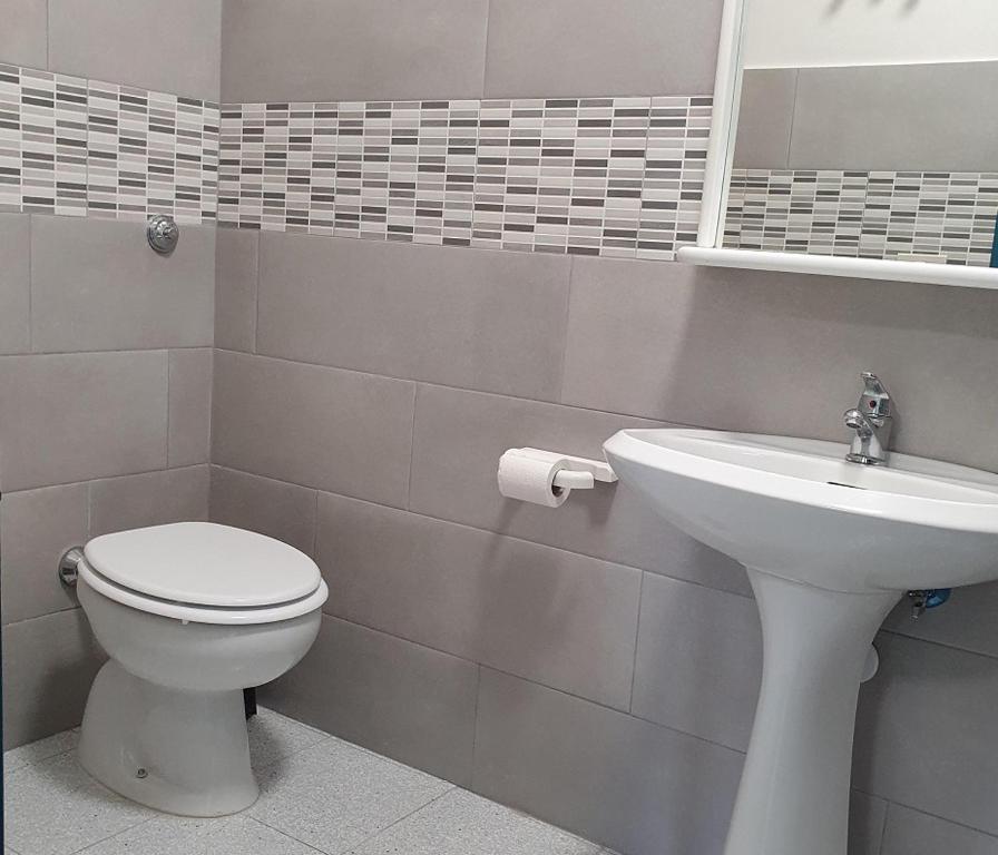 La salle de bains est pourvue de toilettes et d'un lavabo. dans l'établissement Hotel Pixunte, à Policastro Bussentino