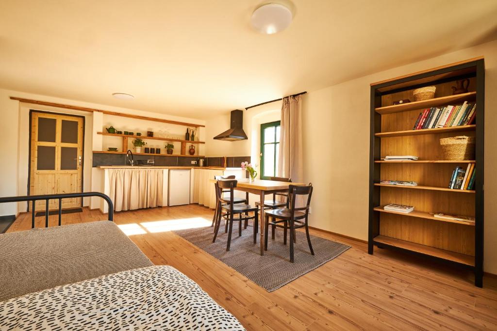 a room with a table and chairs and a kitchen at Statek 85 in Mařenice