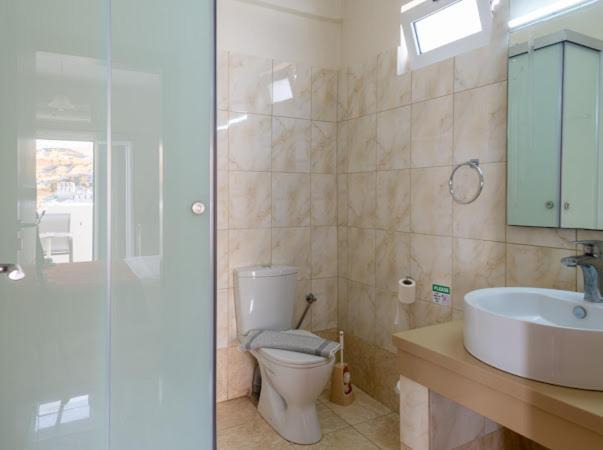 a bathroom with a toilet and a sink at Fantastic Matala 1 in Matala