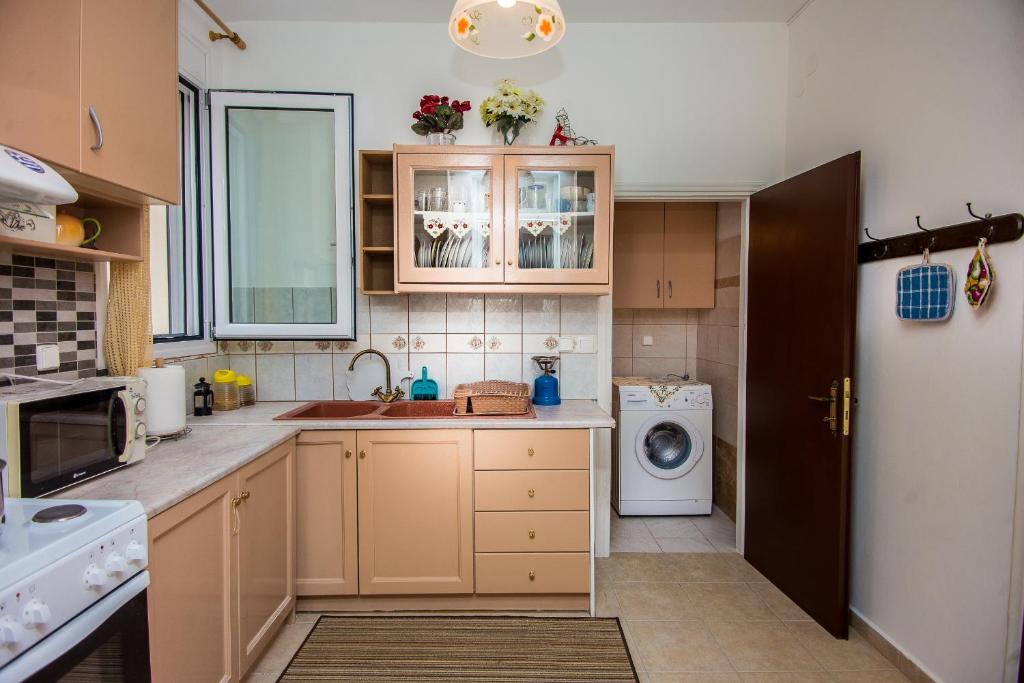 a kitchen with a sink and a washing machine at Christina's House in Argostoli