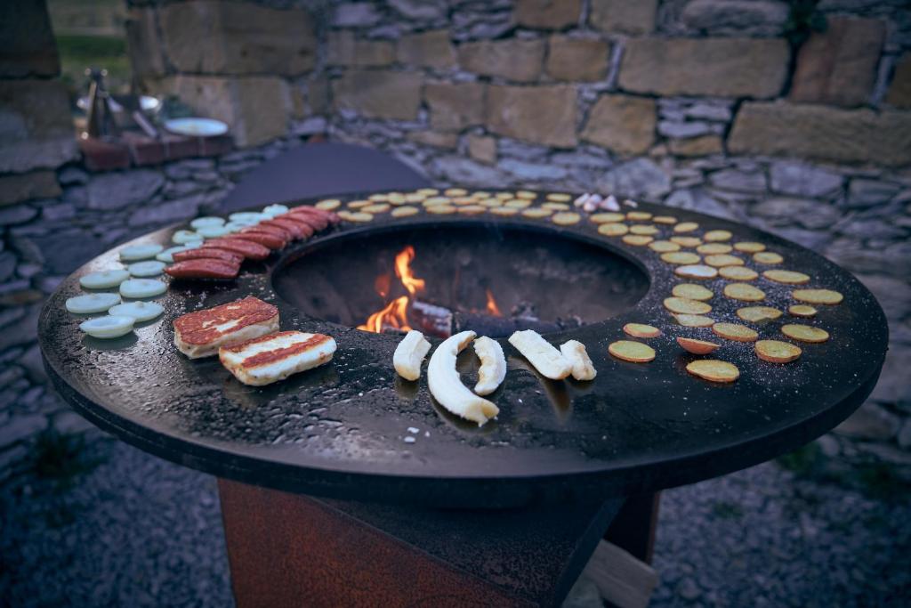 a grill with meat and food on it with a fire at Statek 85 in Mařenice