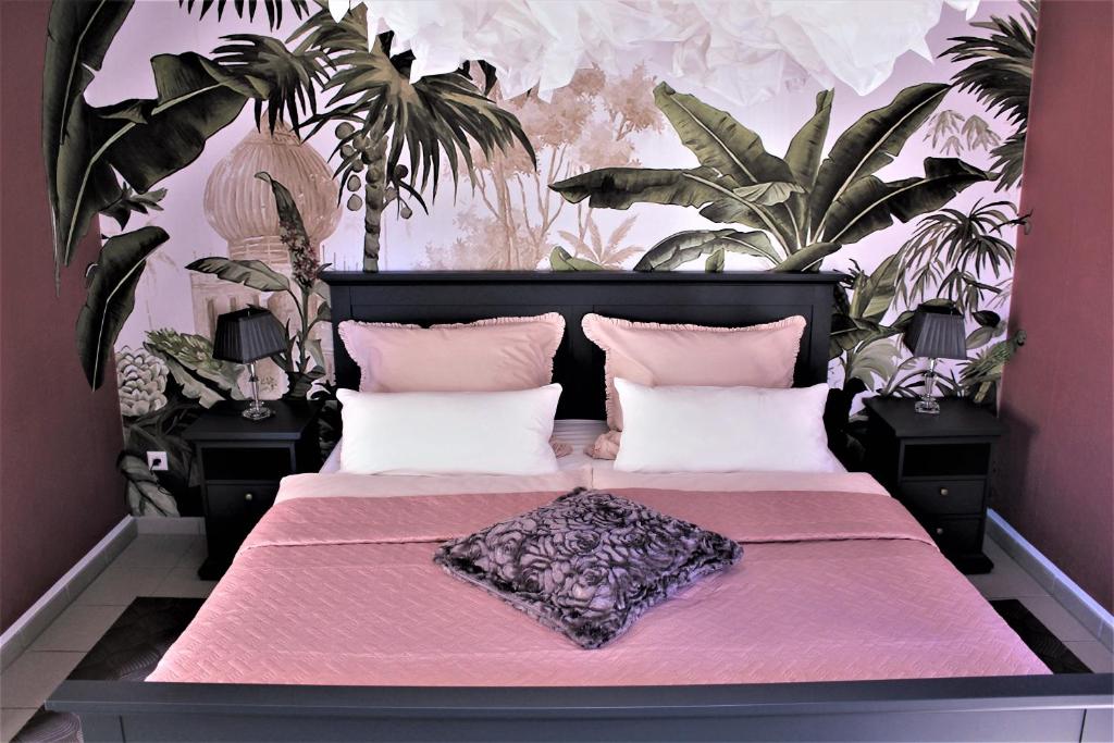a bedroom with a pink bed with pink sheets and plants at Ferienwohnungen zum Zilles in Treis-Karden