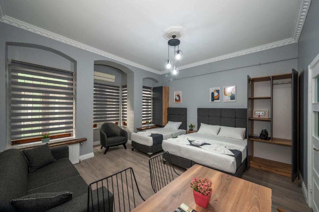 1 dormitorio con cama, sofá y mesa en Taxim Trend Suites, en Estambul