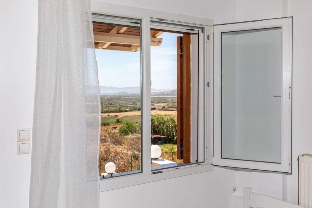 a bathroom with a window with a view of a field at Stamatina House in Glinado Naxos