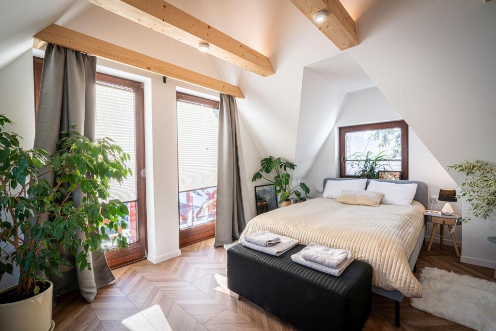 a bedroom with a bed and large windows at Apartamenty zaSzczyty in Kościelisko