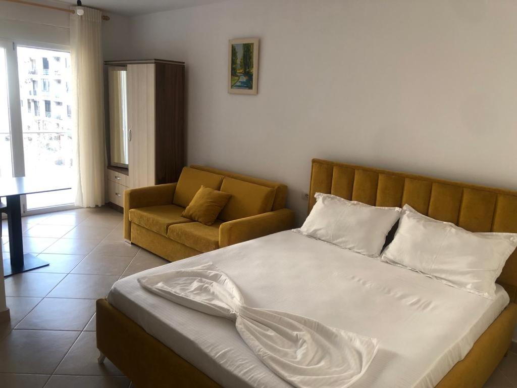 a bedroom with a bed and a couch in it at Hotel MARIO, Shengjin in Lezhë