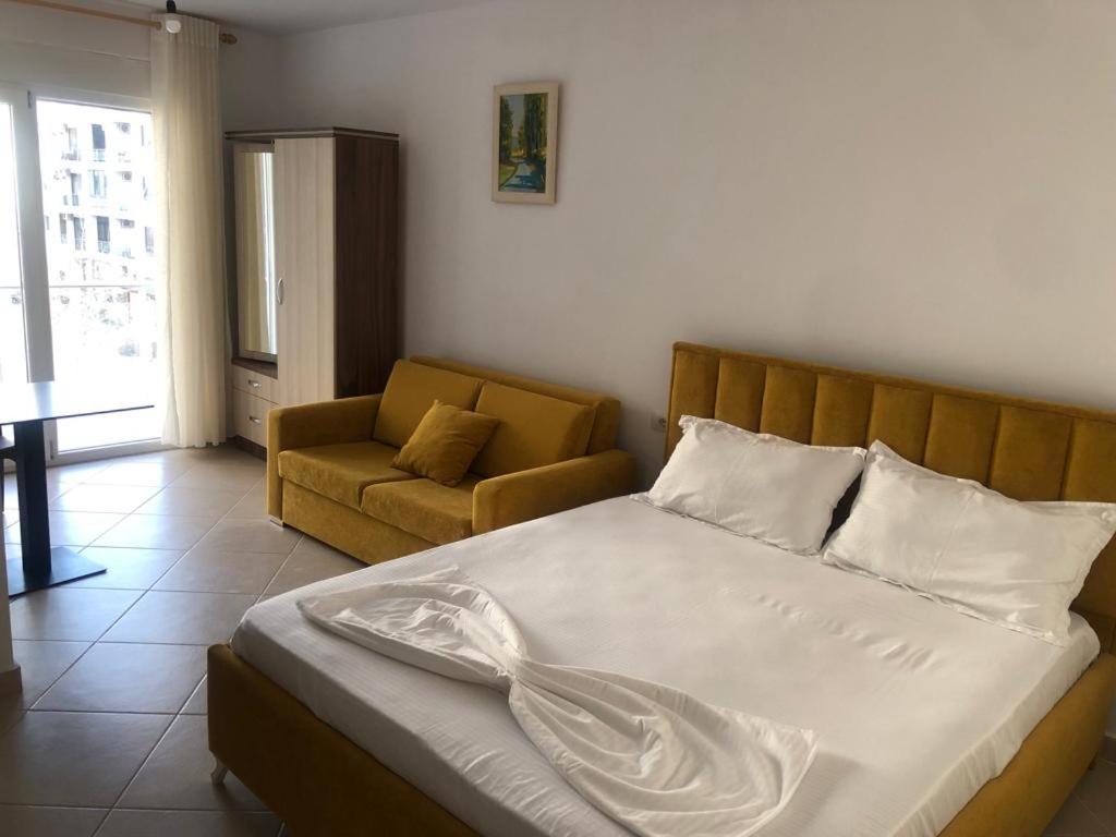 a bedroom with a bed and a couch in it at Hotel MARIO, Shengjin in Shëngjin