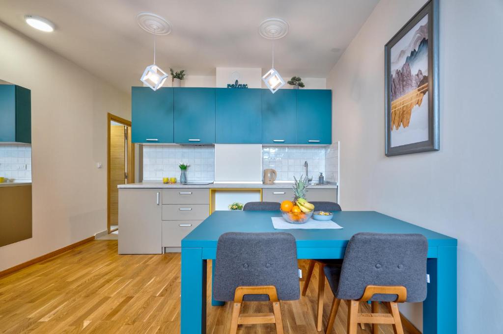 cocina con mesa azul y sillas en Apartman - Casa Emma- Zlatibor, en Zlatibor