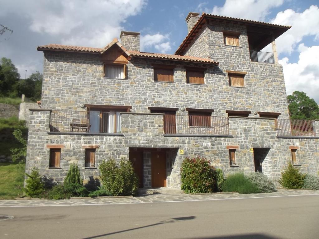 une grande maison en pierre avec un toit dans une rue dans l'établissement Mirador Gavin, à Gavín