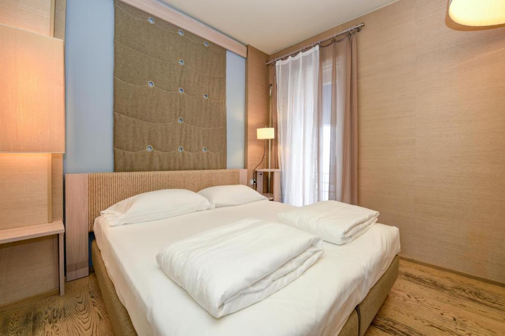 Uma cama ou camas num quarto em Hotel Flaminia