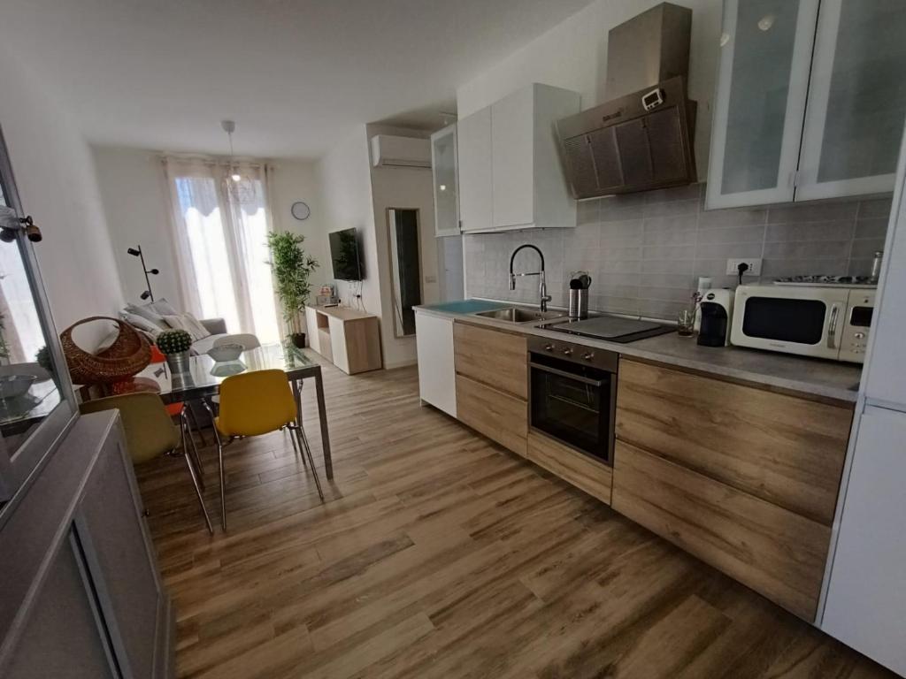 a kitchen with wooden floors and a table and a kitchen with appliances at Il PolpoLeo in Porto Azzurro Isola d'Elba in Porto Azzurro