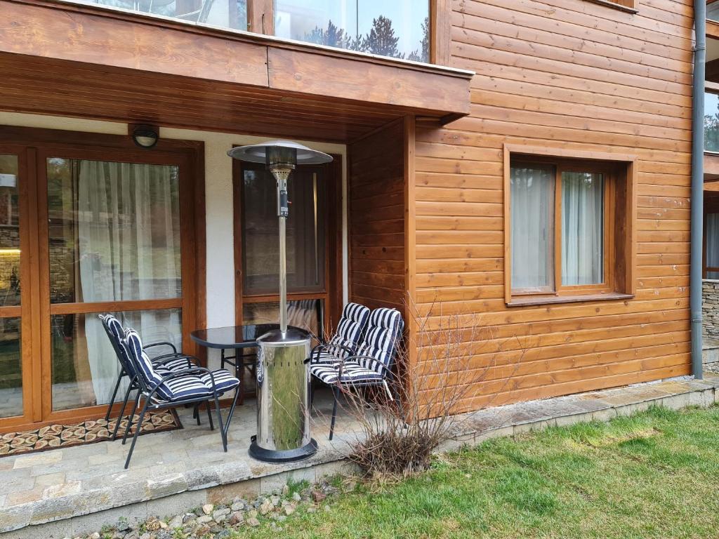 a patio with chairs and a table on a house at Pirin Golf Apartment HOME with private garden in Bansko