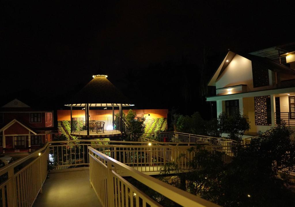 a building with a gazebo at night at Feliz Homes Kottakkal in Kottakkal