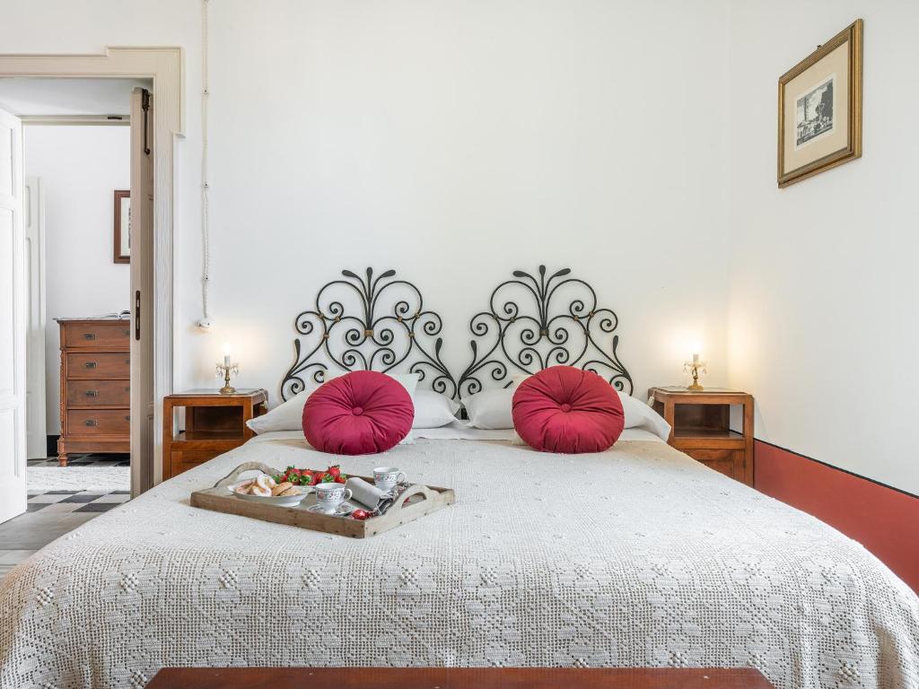 una camera da letto con un grande letto con cuscini rosa di PALAZZO CHERCHI a Dorgali