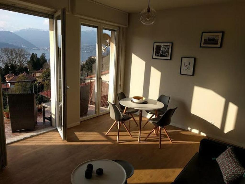 een kamer met een tafel en stoelen en een balkon bij Bellavista Lago Maggiore in Cerro Lago Maggiore
