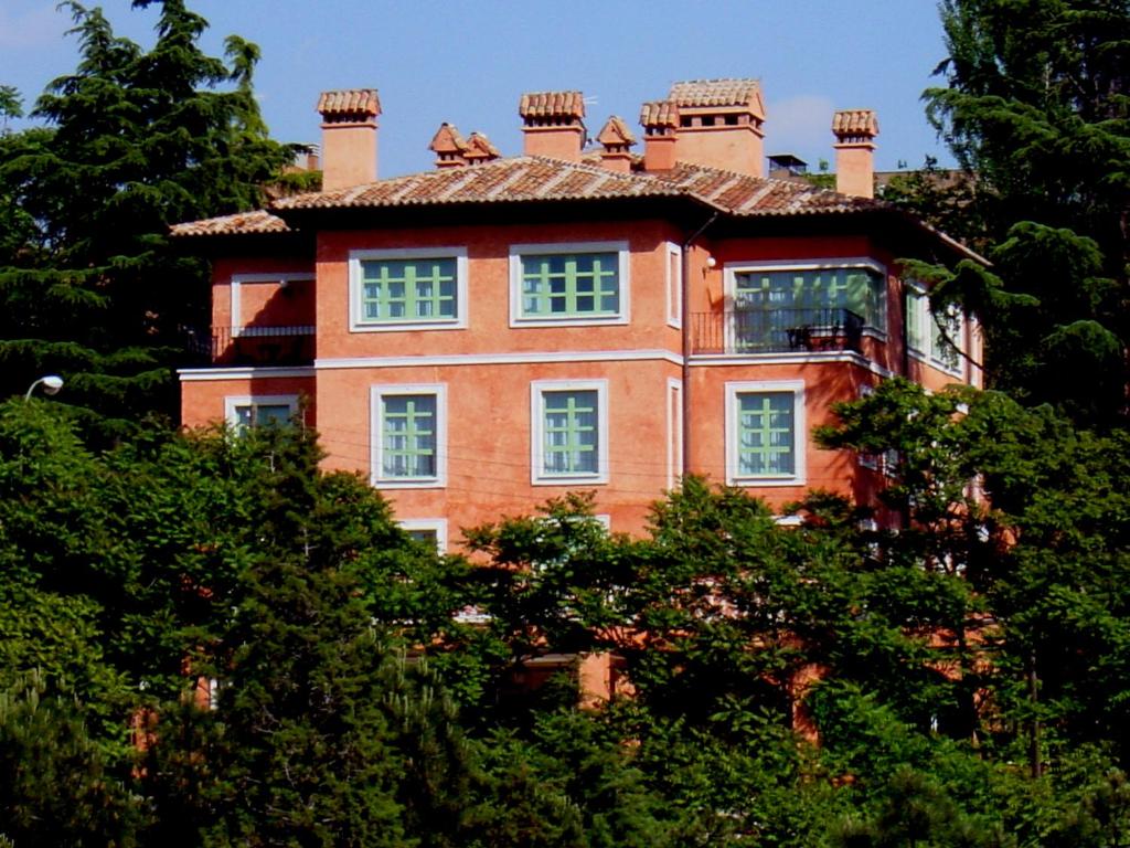 a large brick house on top of some trees at La Quinta de los Cedros in Madrid
