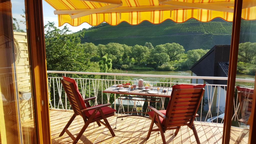 a patio with a table and chairs on a balcony at Casa Barzen - Stilvoll Urlauben an der Mosel in Reil