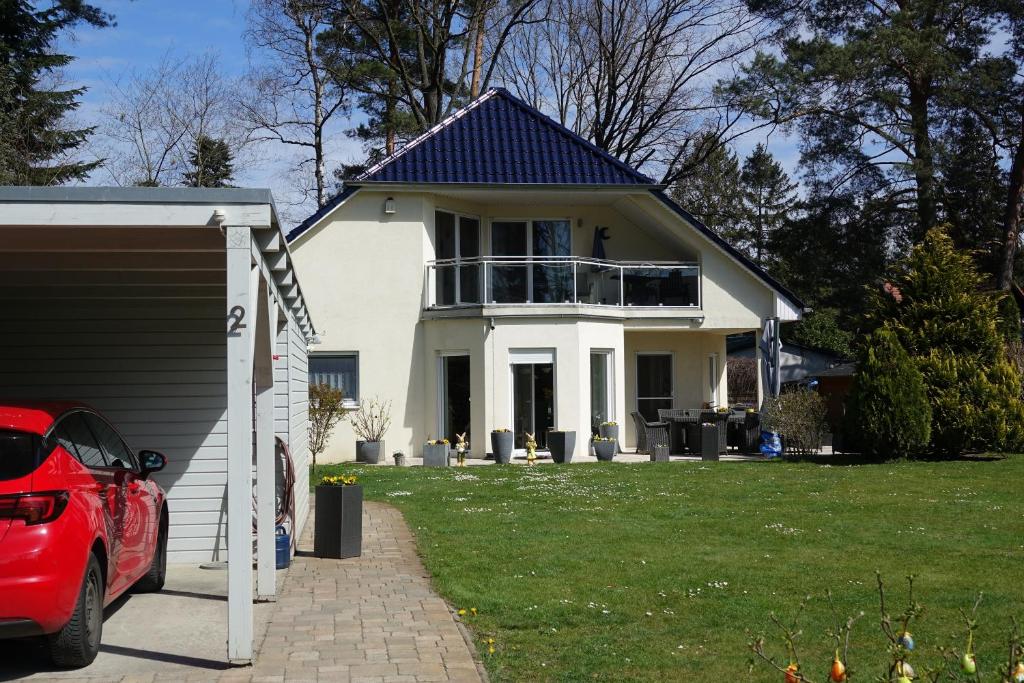 ein weißes Haus mit Balkon darüber in der Unterkunft Ferienwohnung Thuja in Wandlitz