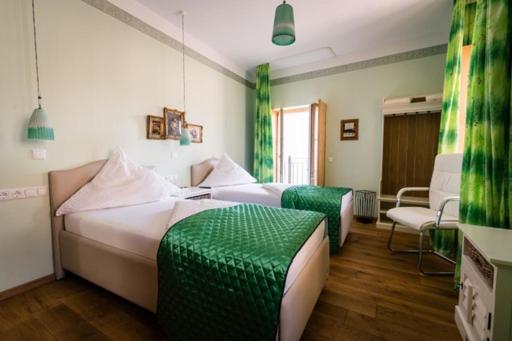 duas camas num quarto com verde e branco em Hotel Belle Vue Volkach em Volkach