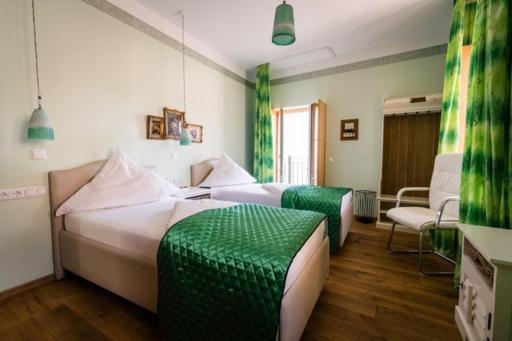 2 Betten in einem Zimmer mit Grün und Weiß in der Unterkunft Hotel Belle Vue Volkach in Volkach