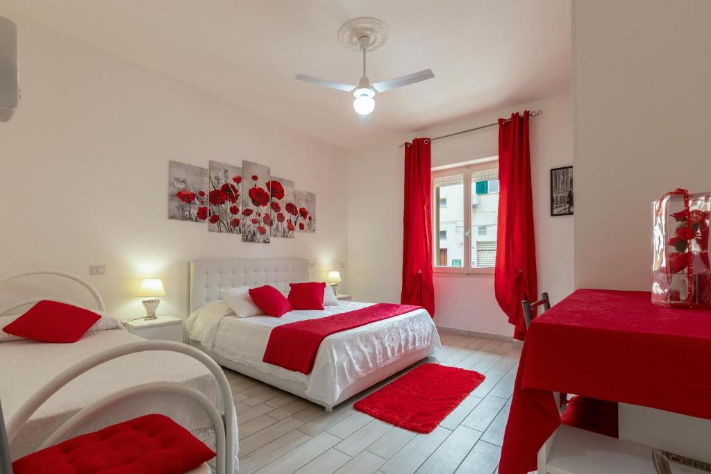 アルゲーロにあるJadianas Guest Houseのベッドルーム1室(ベッド2台、赤いカーテン付)