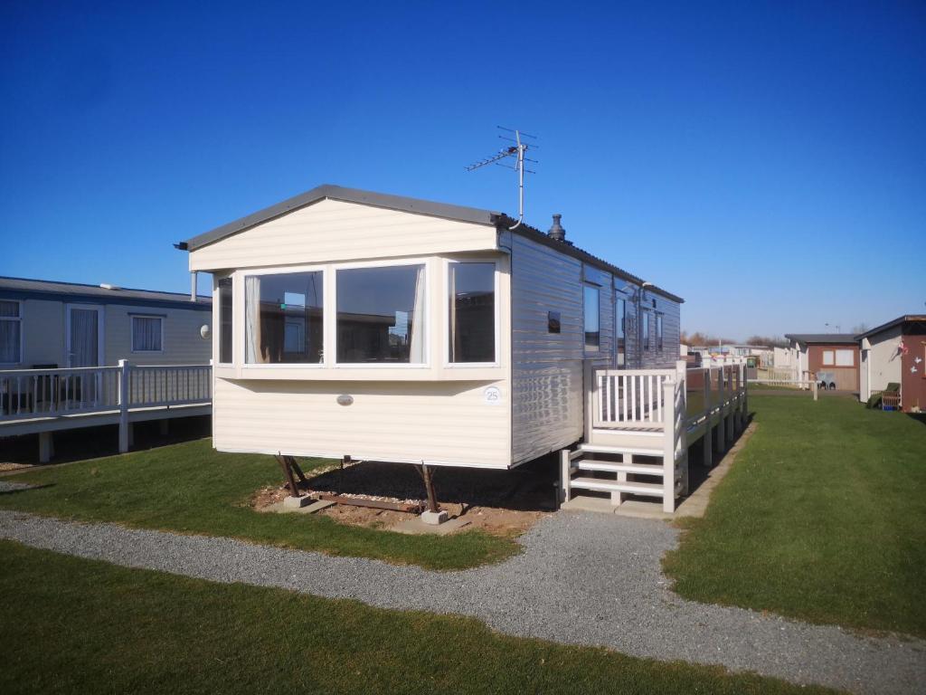 a tiny house sitting on top of a yard at Caravan L25 in Mablethorpe