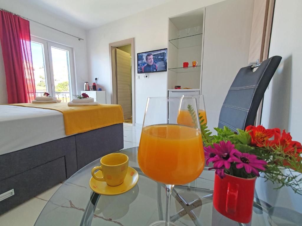 una mesa de cristal con una bebida y un jarrón con flores en Holiday Home Gordana, en Hvar