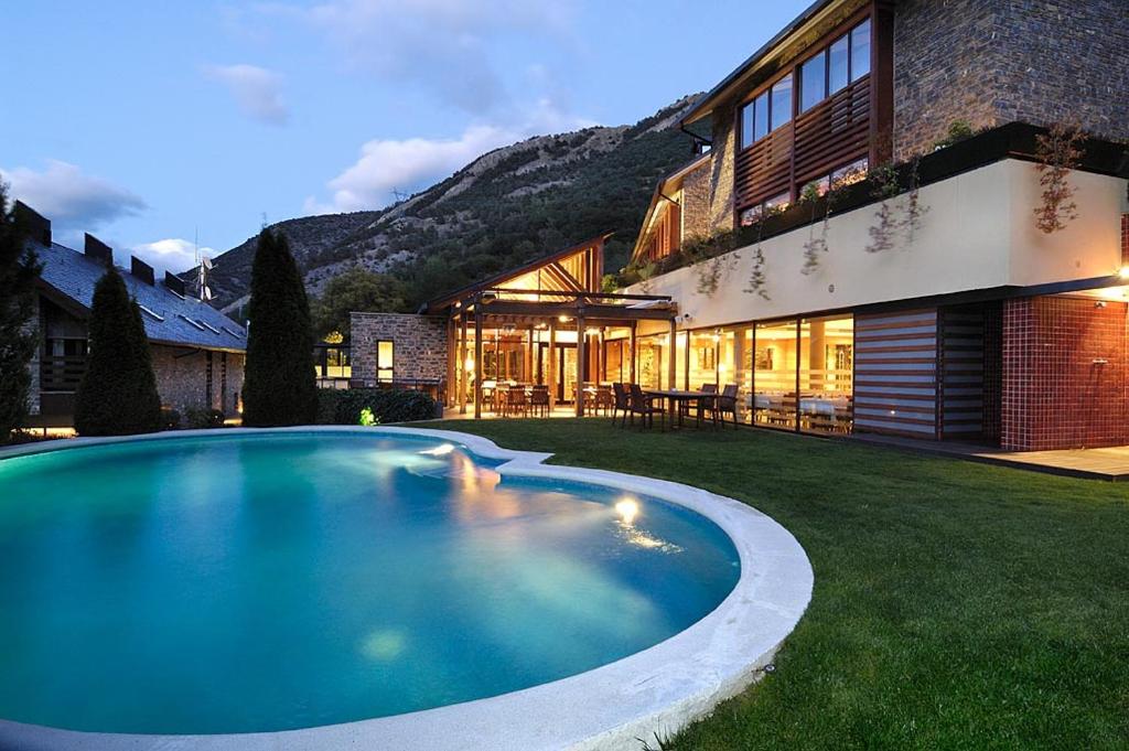 una gran piscina frente a una casa en Hotel Riberies & SPA, en Llavorsí