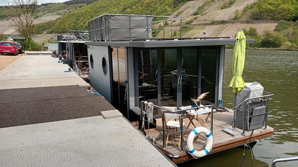 a house boat tied to a dock in the water at Hausboot Moselrose in Pölich in Detzem