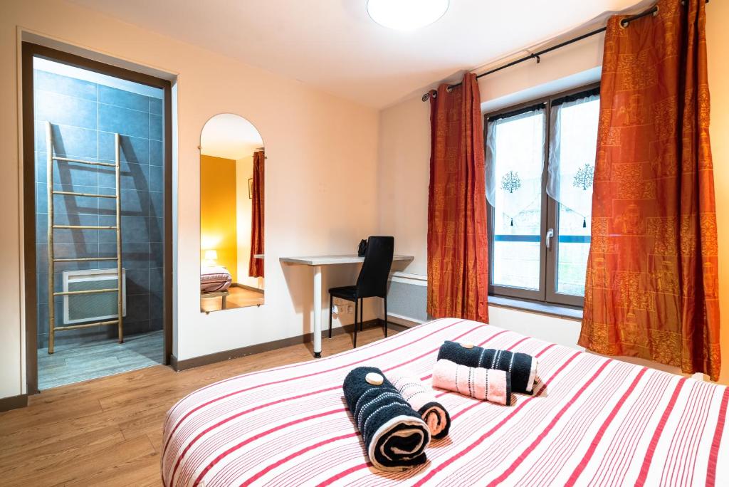 um quarto com uma cama, uma secretária e uma janela em Le LENNON - Centre Ville T2 - Rez-de-chaussée em Limoges