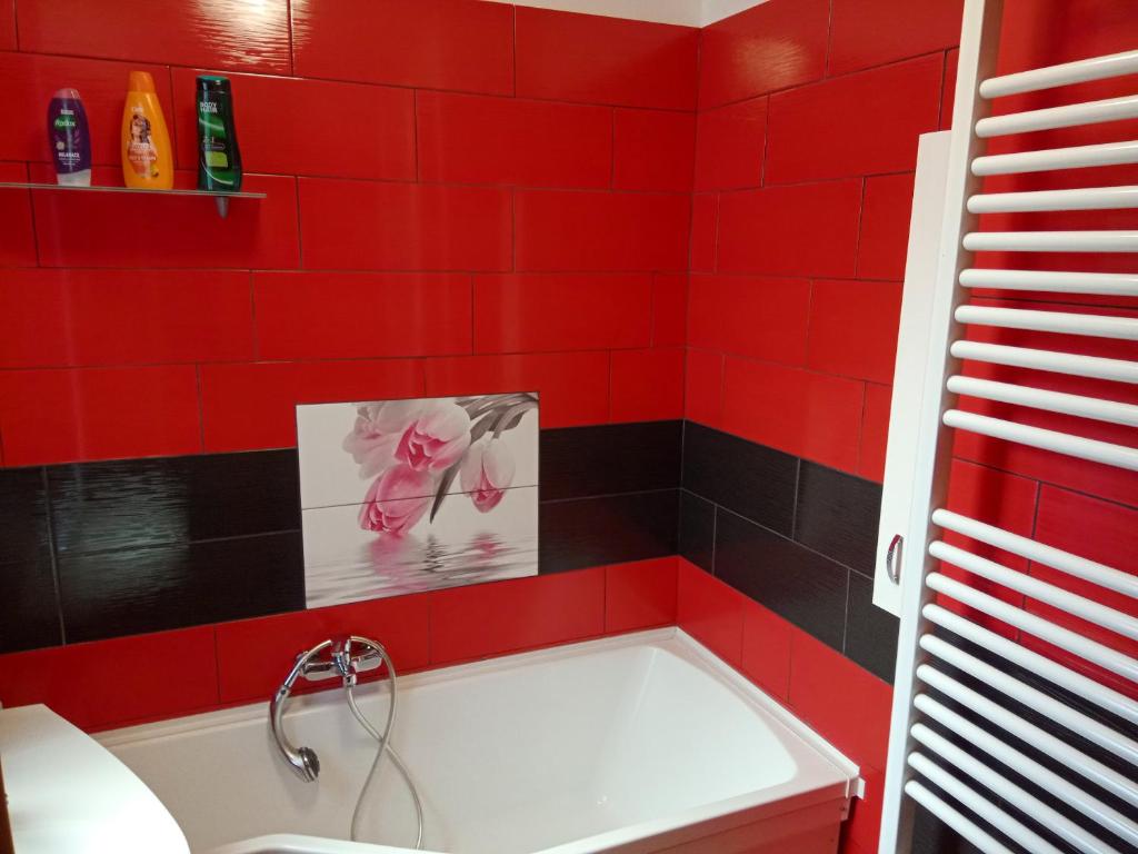 a red tiled bathroom with a white bath tub at DUKLA HERO in Olomouc