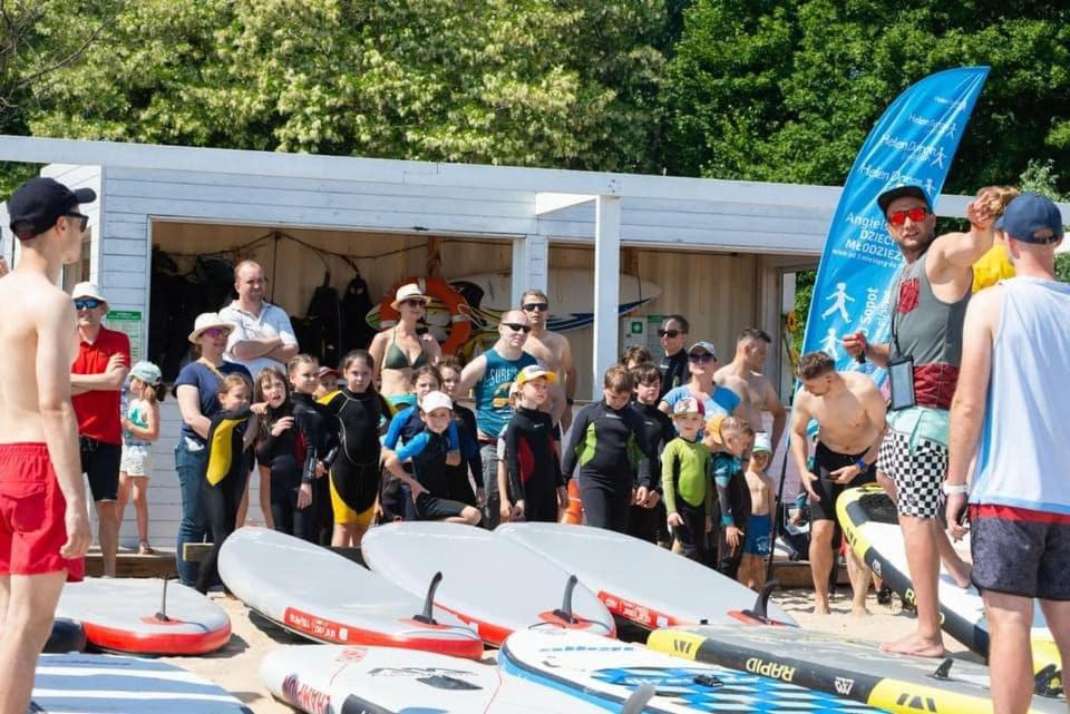 a group of people standing around surfboards on the beach at Sopot 34 przy plaży in Sopot