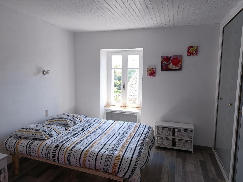 a white bedroom with a bed and a window at Jolie studio récemment rénové in Marseillette