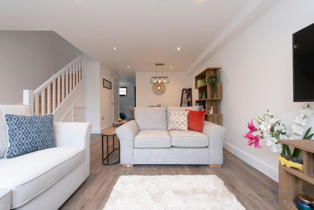 a living room with a white couch and a chair at Park View Apartments in London