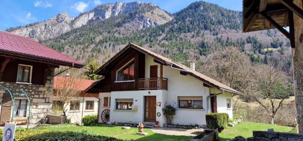 a house with a mountain in the background at Chez Mémé Cour in Bellevaux