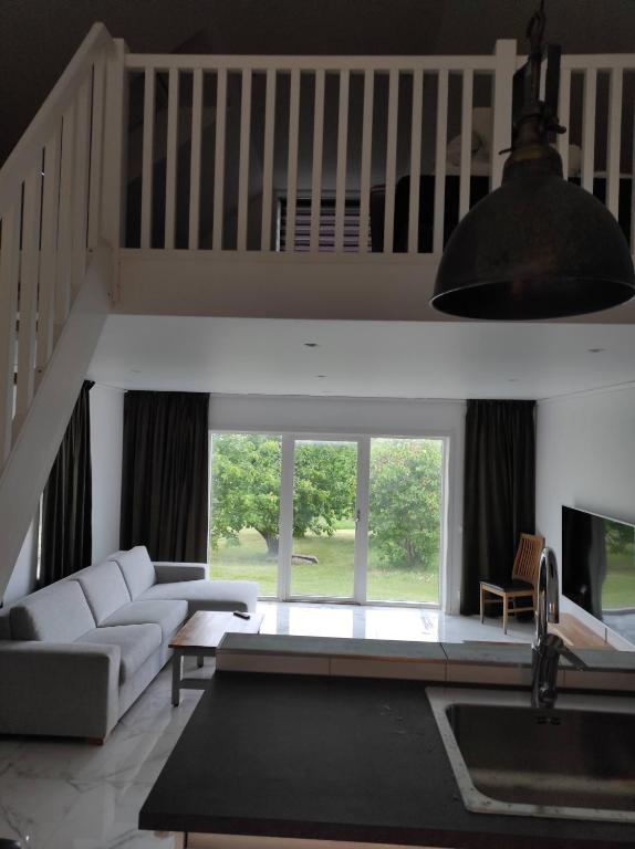 a living room with a white couch and a tv at Villa Wettervy in Gränna