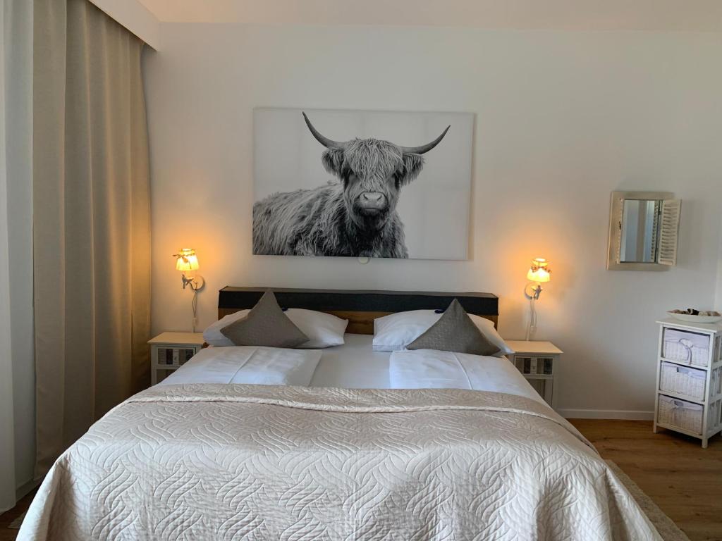 Schlafzimmer mit einem Bett mit einem Bild eines Stiers in der Unterkunft Warmbad Apartments in Villach