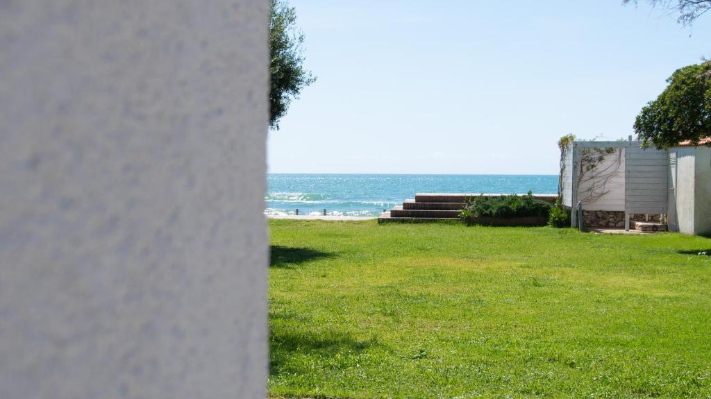 widok na ocean z trawnika z budynkiem w obiekcie Villa degli Squali Suite Home w mieście Terracina