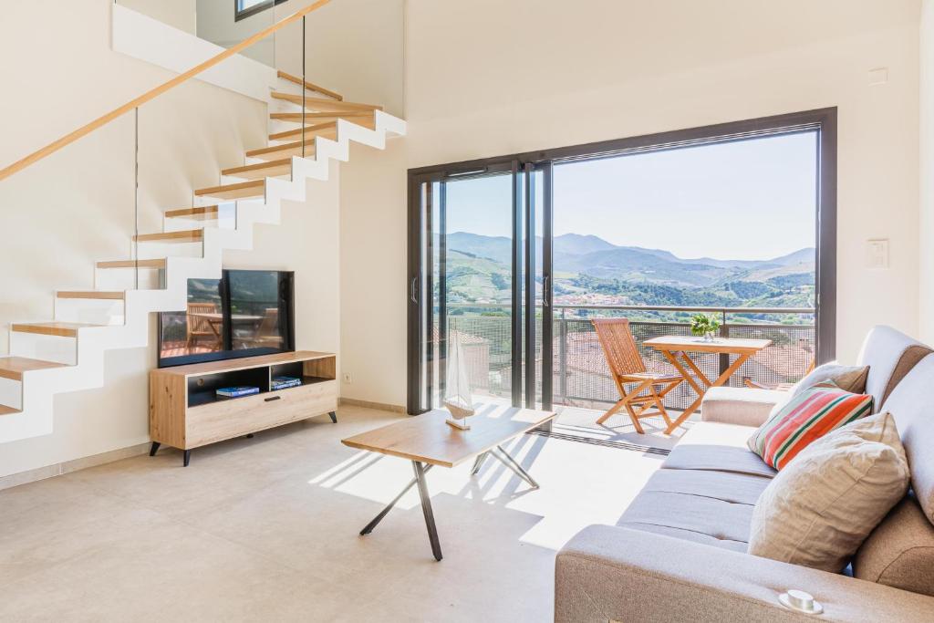 a living room with a couch and a staircase at Regina's Banyuls - Modern and brand new apartment in Banyuls-sur-Mer