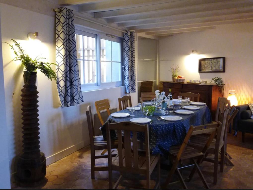 Maison de village à Omerville في Omerville: غرفة طعام مع طاولة وكراسي زرقاء