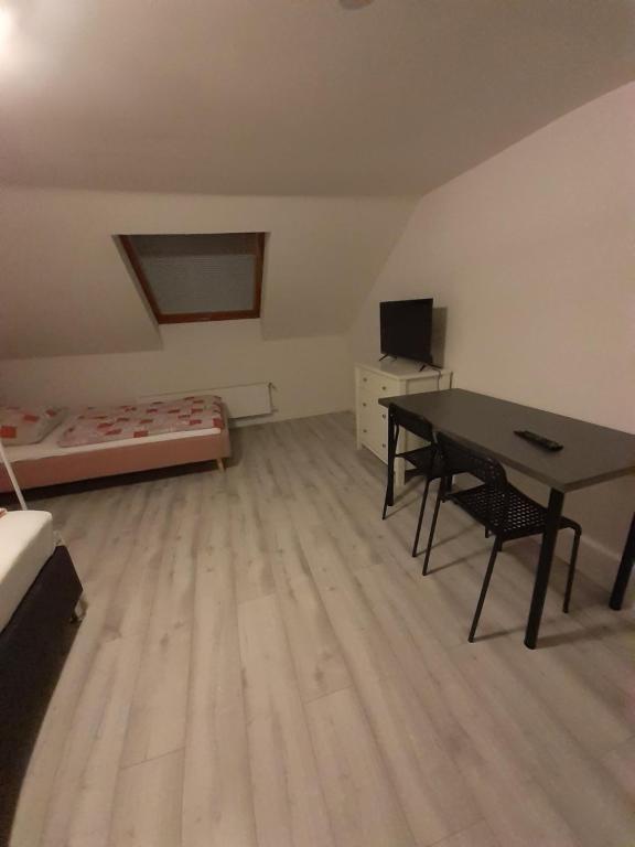 Zimmer mit einem Tisch, einem Bett und einem Schreibtisch in der Unterkunft Pension Rückert in Kassel